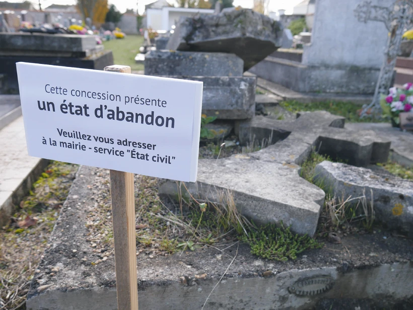 Panneau annonçant l'état d'abandon d'une sépulture dans un cimetière